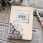Notebook with motivational quote on a newspaper background