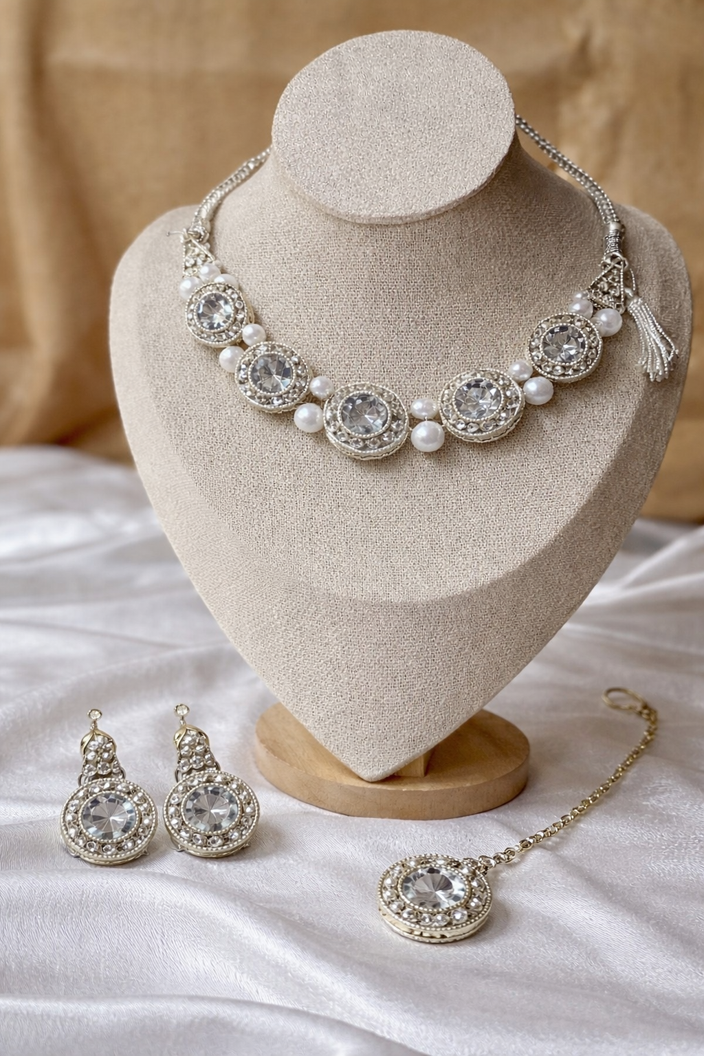Jewelry set including necklace, earrings, and hair accessory on a heart-shaped stand.